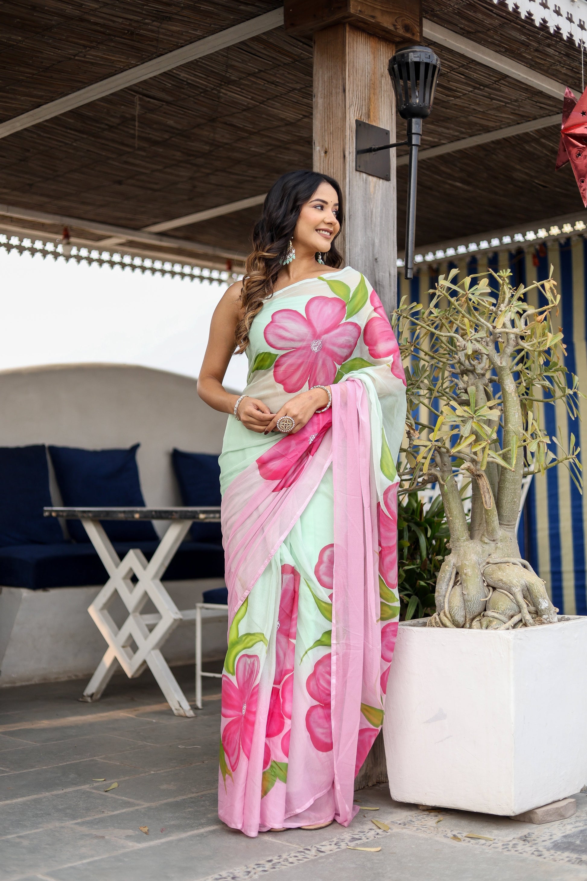 Elegant designer saree for women featuring large floral prints in pink and mint green colors