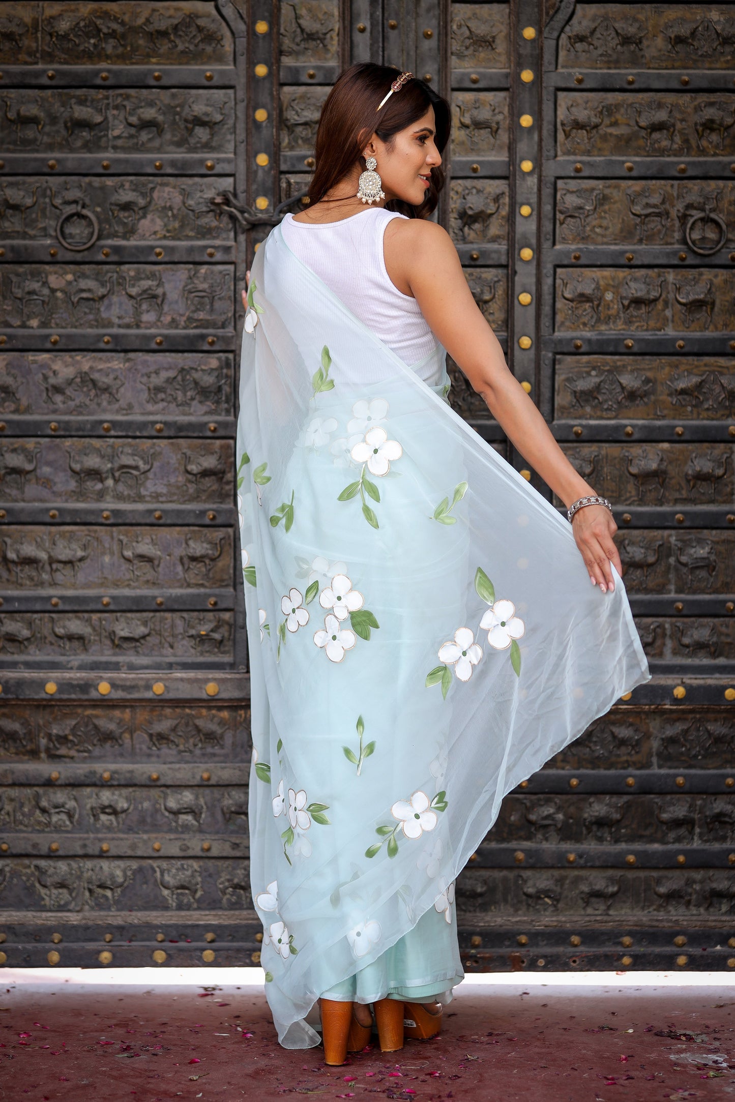 Elegant light blue designer saree with floral embroidery, showcasing light and airy fabric draped beautifully.