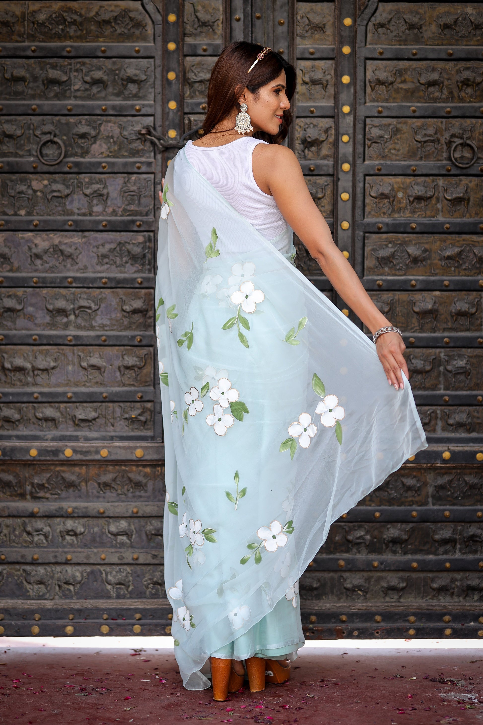 Elegant light blue designer saree with floral embroidery, showcasing light and airy fabric draped beautifully.