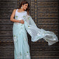 Elegant light blue designer saree with floral embroidery, styled with matching accessories
