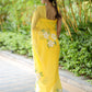 Elegant yellow designer saree with floral art, featuring a graceful drape and intricate embroidery