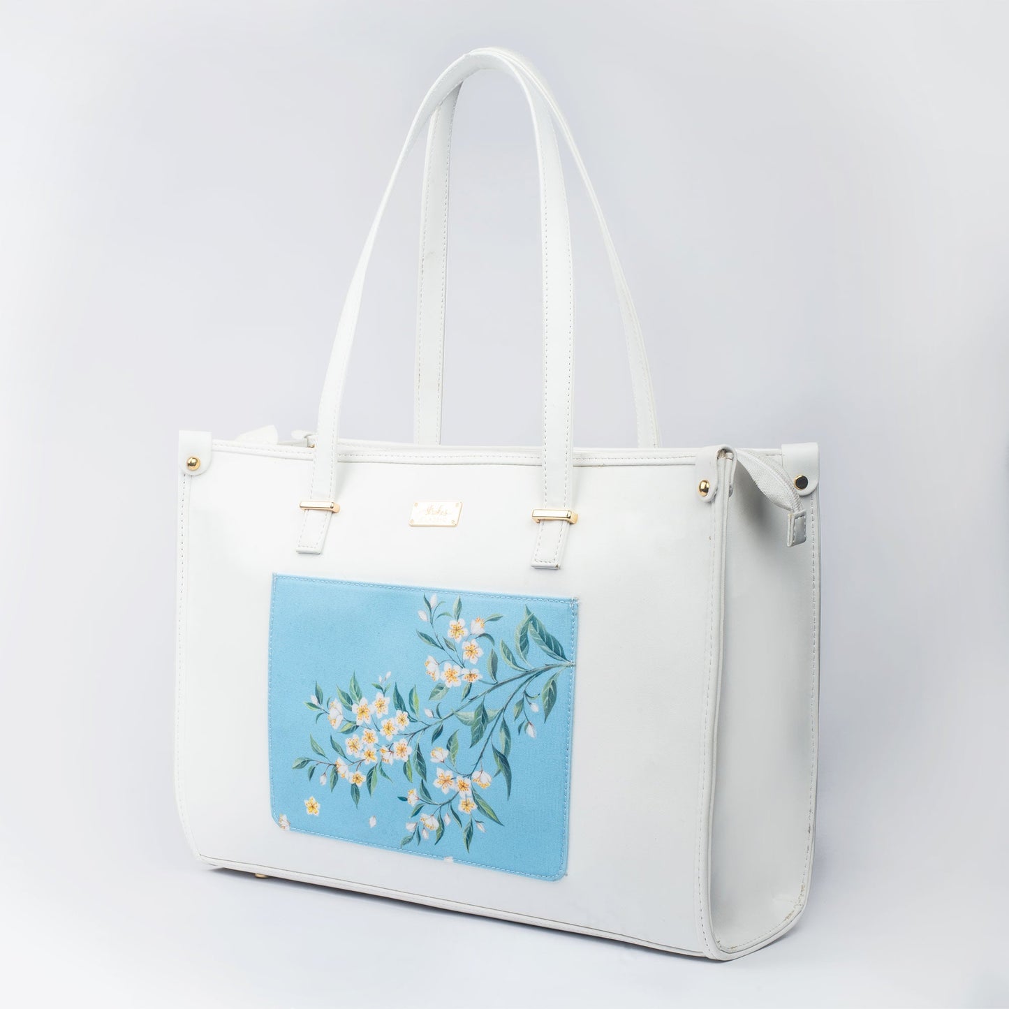 Stylish large designer tote bag in white with floral canvas art for chic daily use