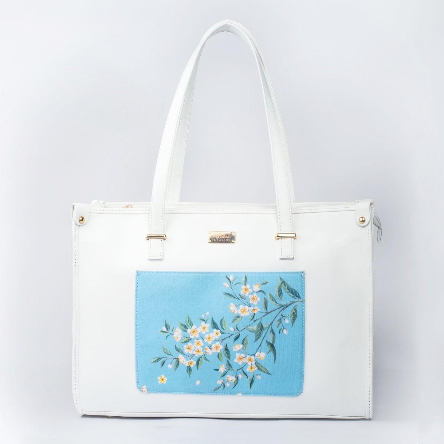 Large designer tote bag in white with a floral blue patch for stylish everyday use