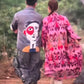 Stylera artistic printed resort shirt on man featuring large abstract face back print as couple walk outdoors