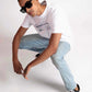 Man wearing Stylera white regular fit t-shirt with graphic print paired with light blue jeans and black sneakers