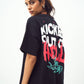 Model wearing Stylera black oversized edgy graphic tee for men and women with red flame and green skeleton back print
