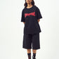 Model wearing Stylera black oversized edgy graphic tee for men and women with long shorts and combat boots
