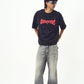 Male model wearing Stylera black edgy graphic tee for men and women with faded wide leg jeans
