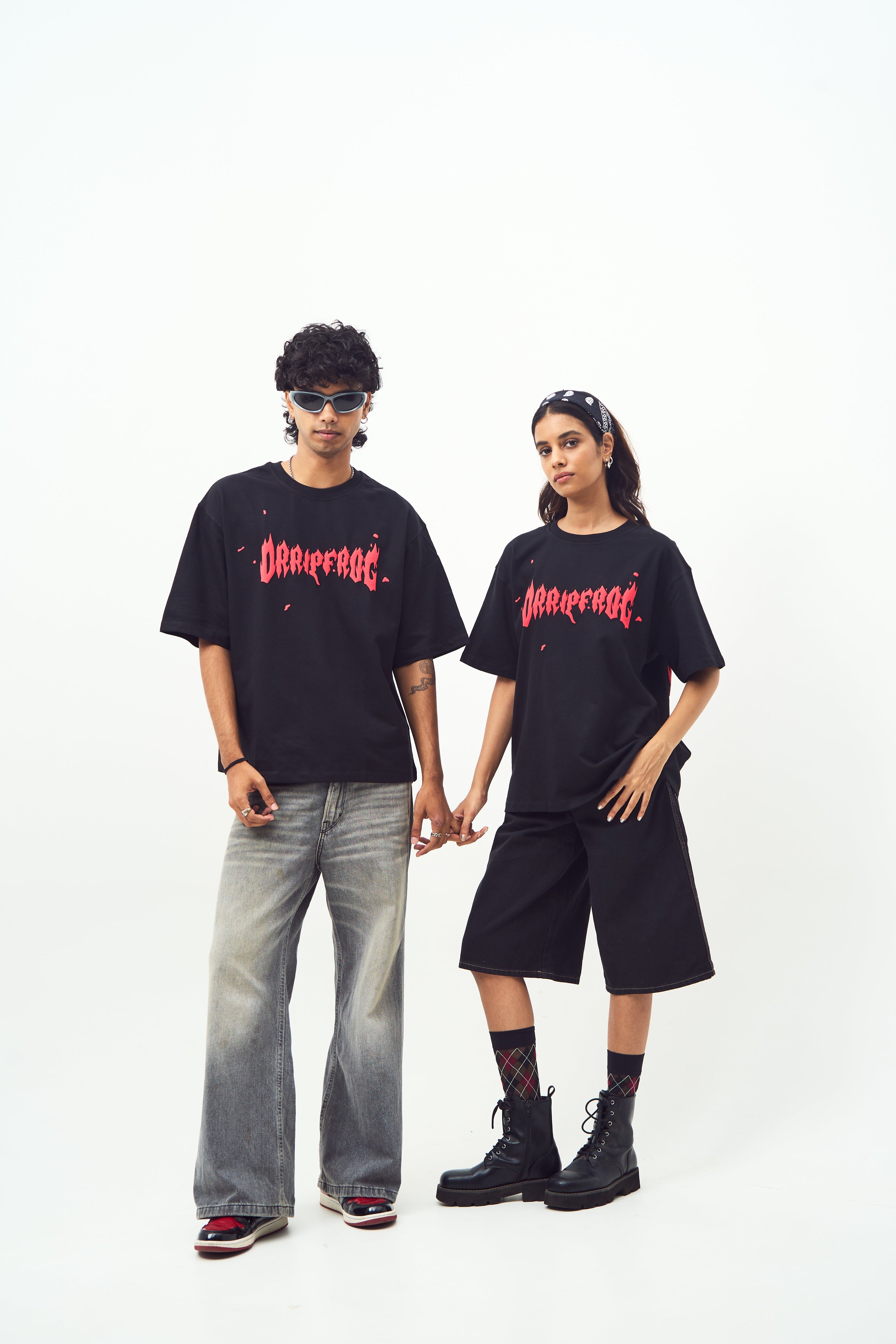 Stylera models holding hands wearing black shirts with red logo styled as edgy graphic tee for men and women
