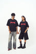 Stylera models holding hands wearing black shirts with red logo styled as edgy graphic tee for men and women