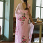 Woman wearing an elegant party wear chiffon saree with floral embroidery in a bright indoor setting