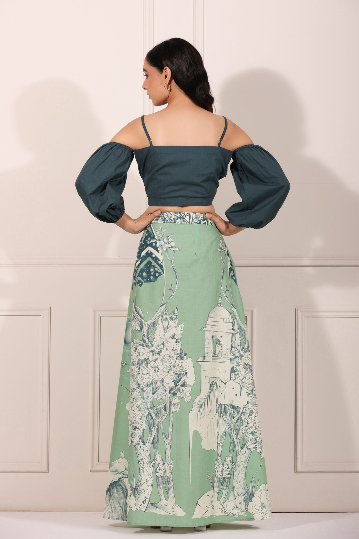 Back view of a woman wearing an ethnic crop top and skirt set featuring puffed sleeves and a floral printed skirt