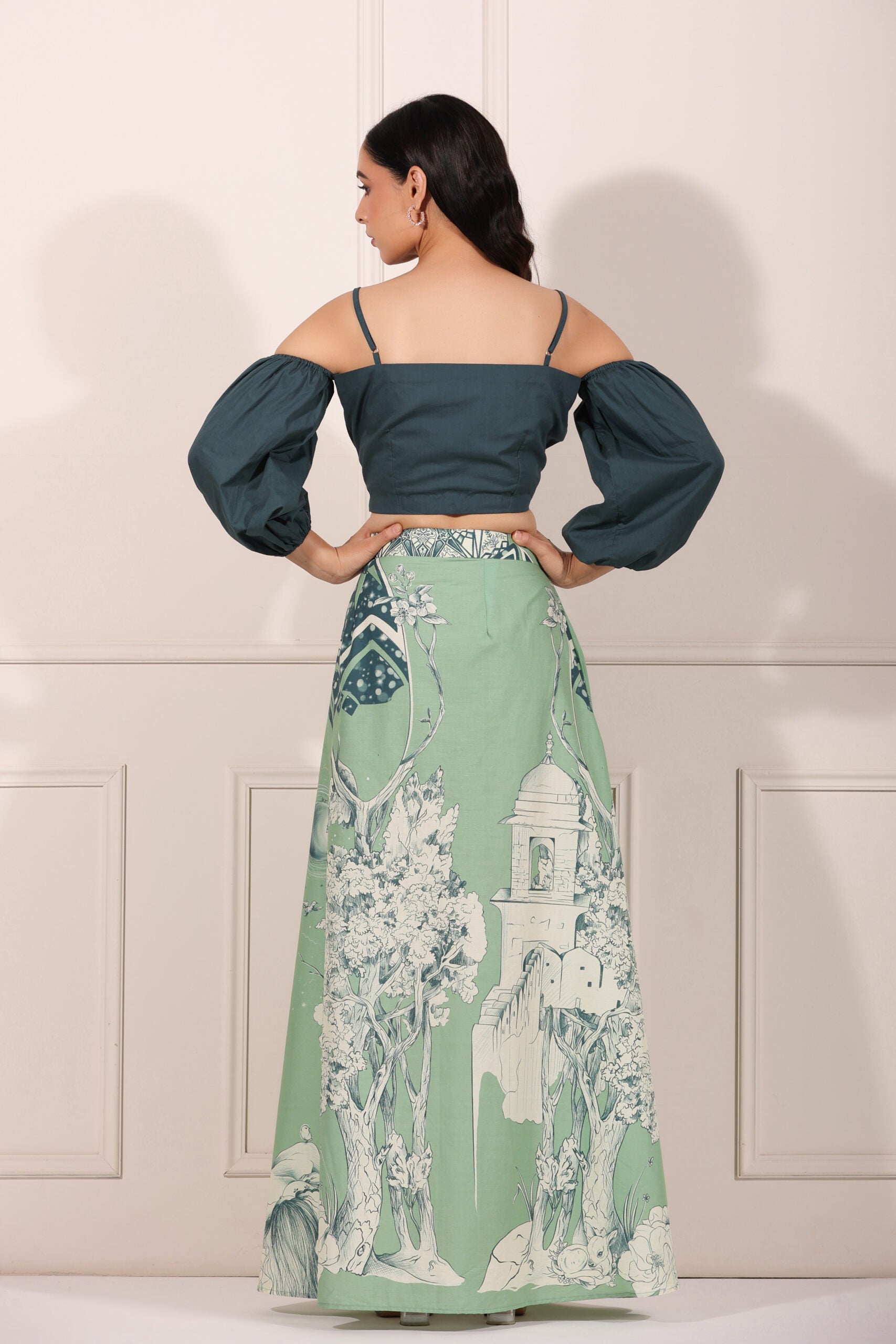 Back view of a woman wearing an ethnic crop top and skirt set featuring puffed sleeves and a floral printed skirt