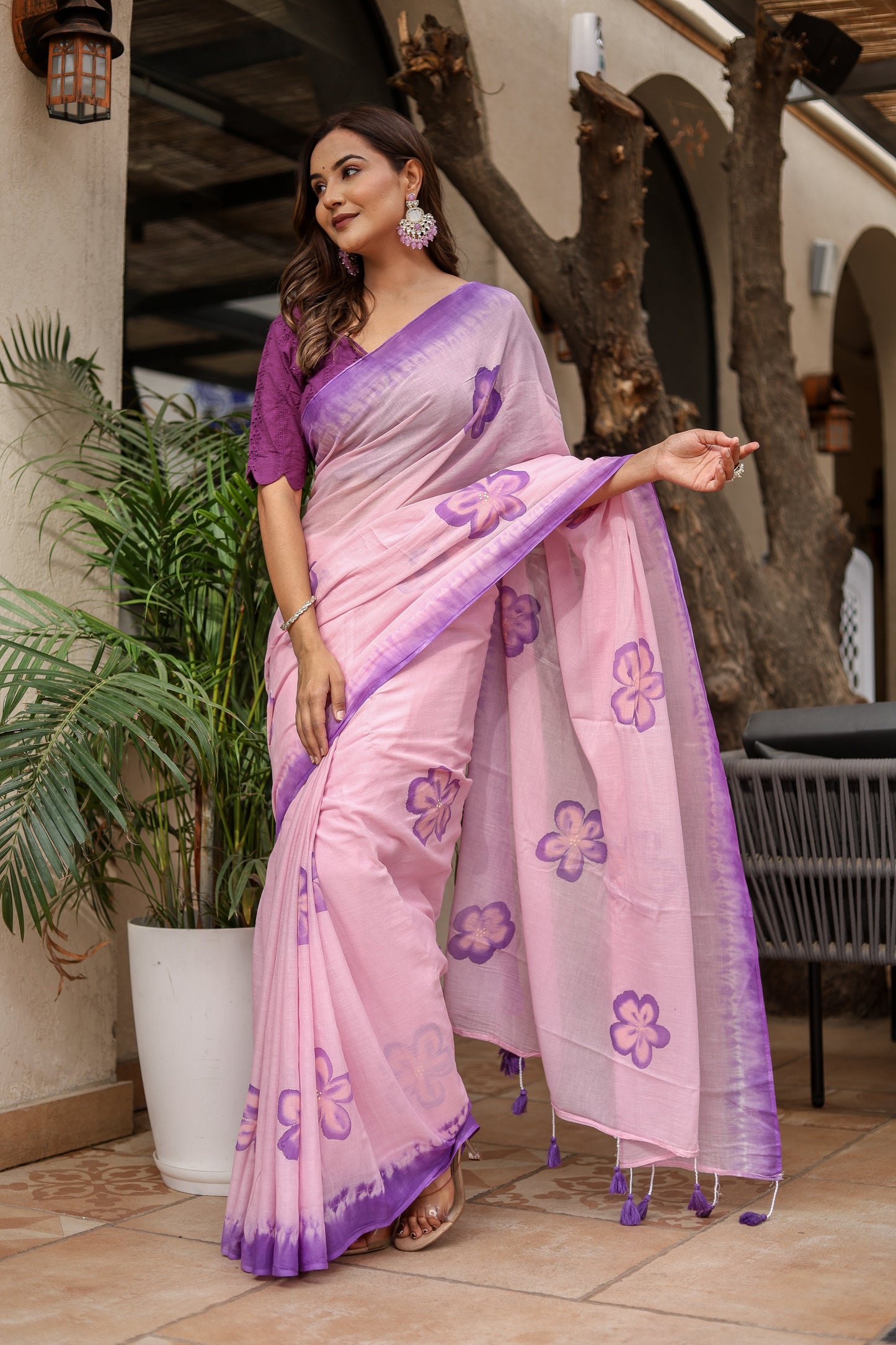 Elegant exclusive designer saree for parties in pink with purple floral designs and a stylish drape