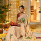 Elegant woman wearing an exclusive handmade Indian saree adorned with floral designs, seated gracefully outdoors