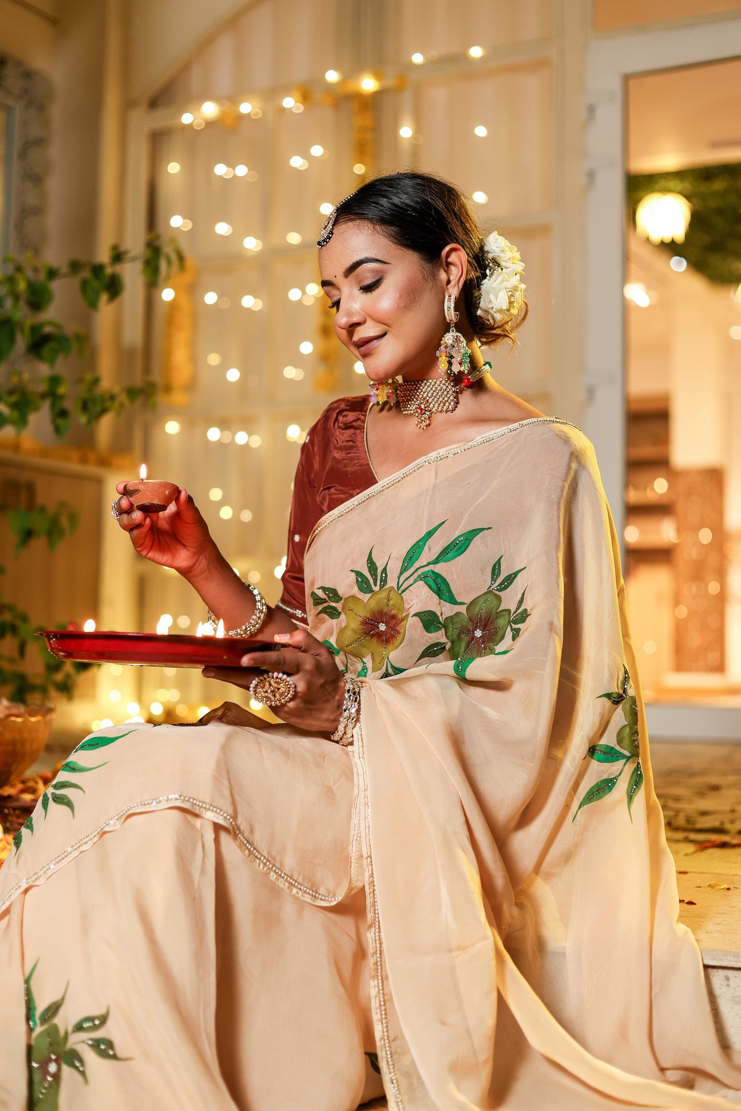 Elegant woman wearing an exclusive handmade Indian saree with floral embroidery, celebrating a festive occasion