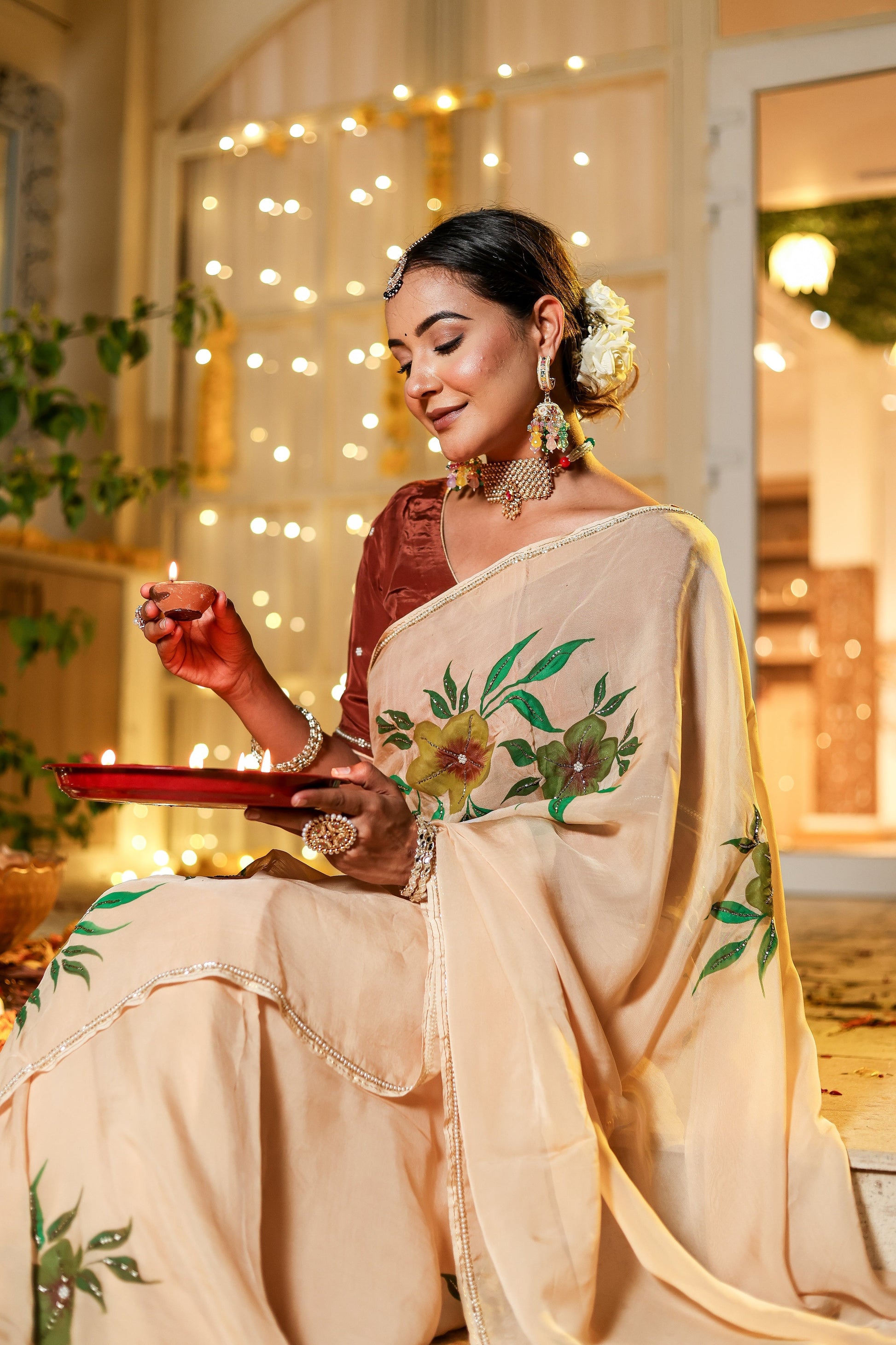 Elegant woman wearing an exclusive handmade Indian saree with floral embroidery, celebrating a festive occasion