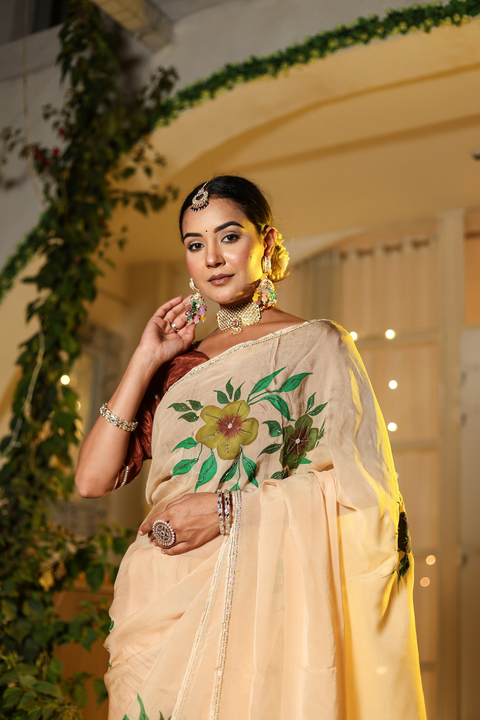 Elegant woman wearing an exclusive handmade Indian saree with floral embroidery and traditional jewelry