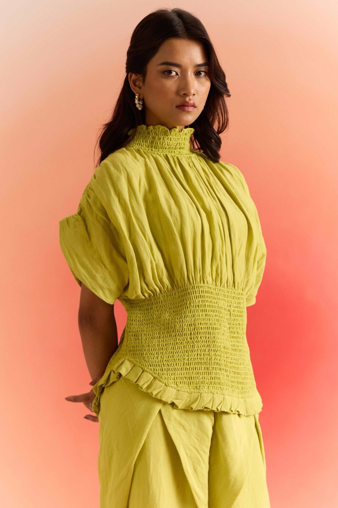 Stylera green smocked top with puff sleeves and ruffled hem on woman