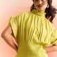 Stylera green smocked top with high neck and ruffle details worn by woman