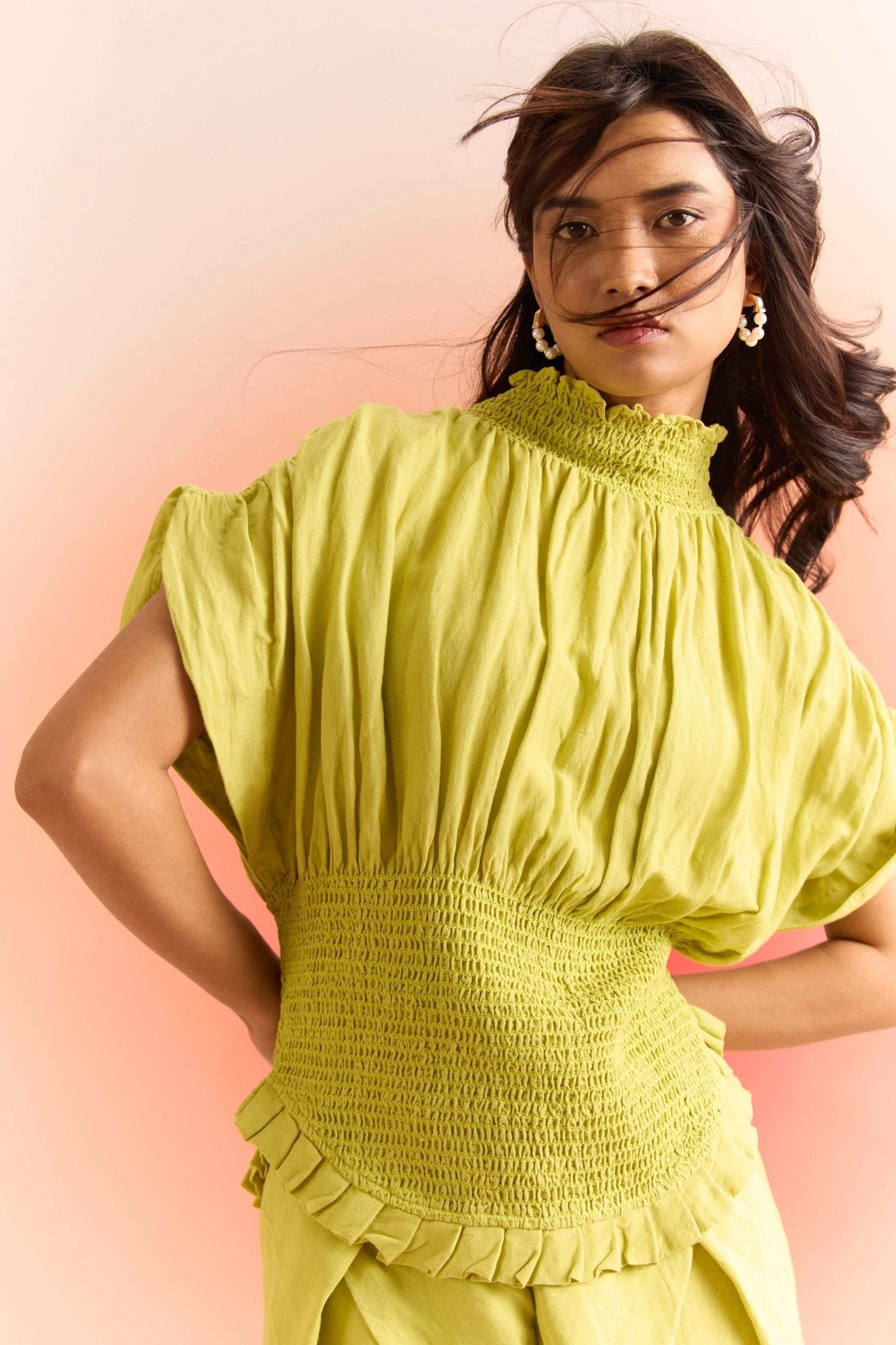 Stylera green smocked top with high neck and ruffle details worn by woman