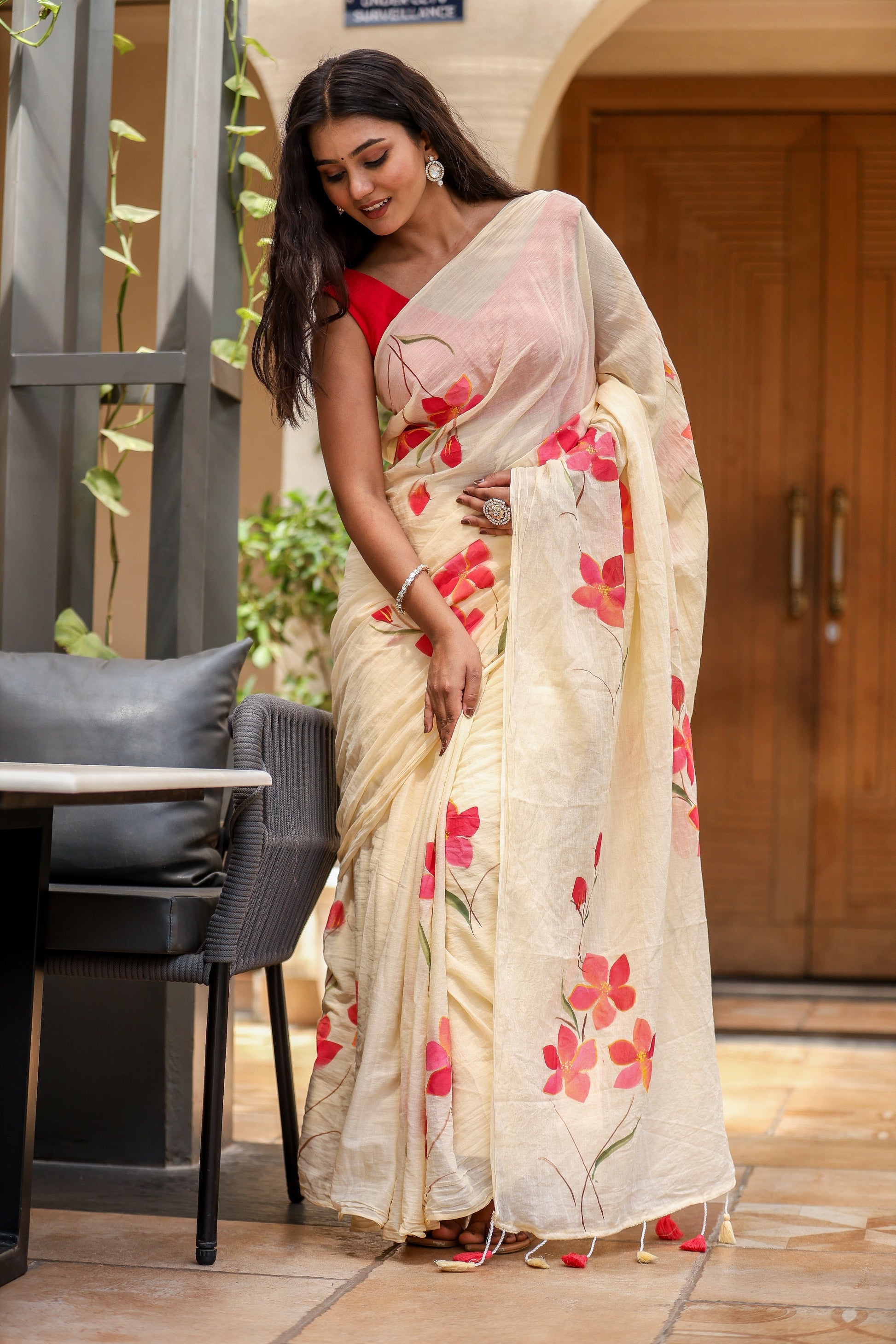 Elegant floral print cream saree with vibrant red flowers, perfect for festive occasions
