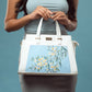 Floral print designer handbag by Stylera with elegant blue floral embroidery on a white base