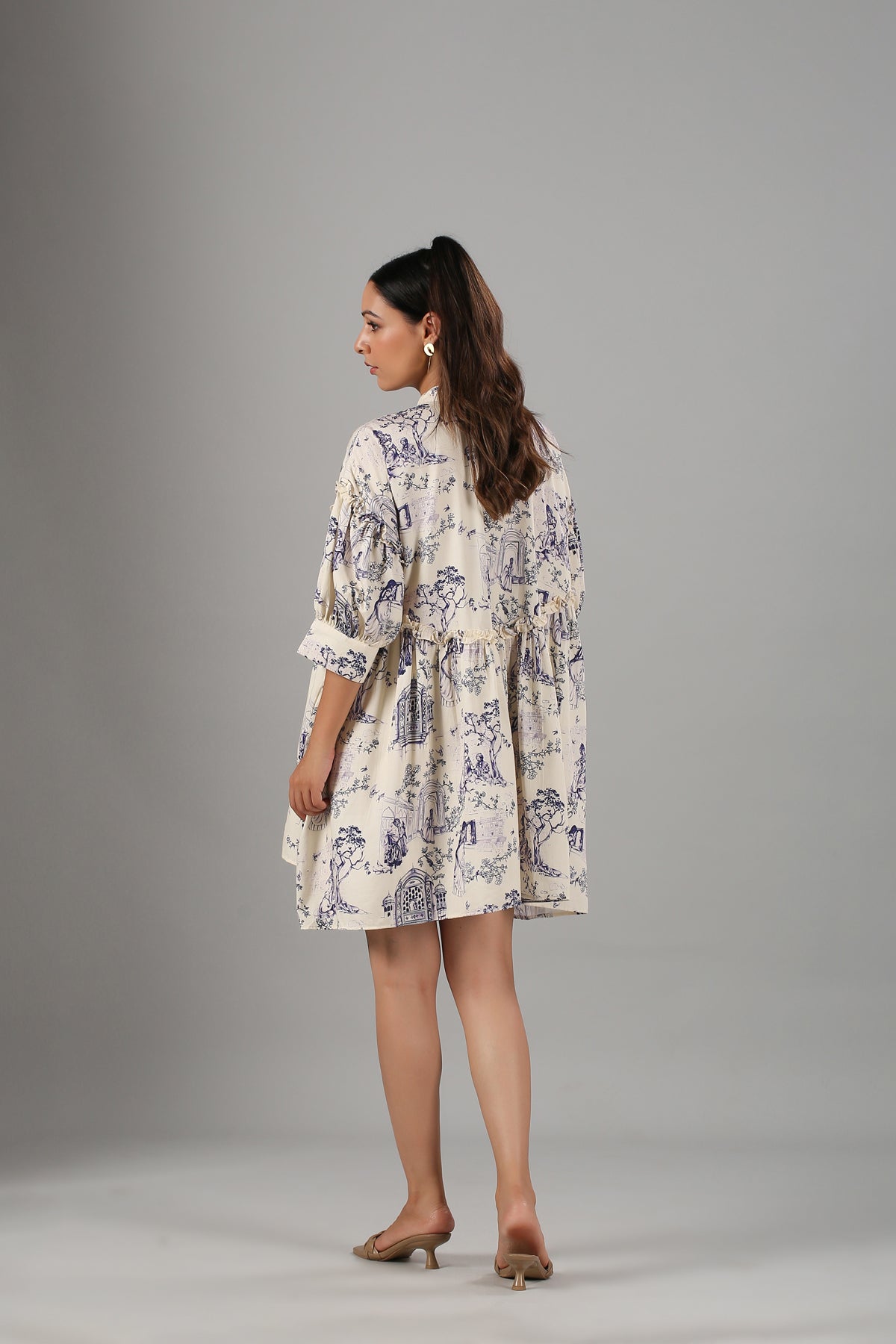 Back view of a Stylera flowy casual short sleeve dress in a light cream color with a floral print