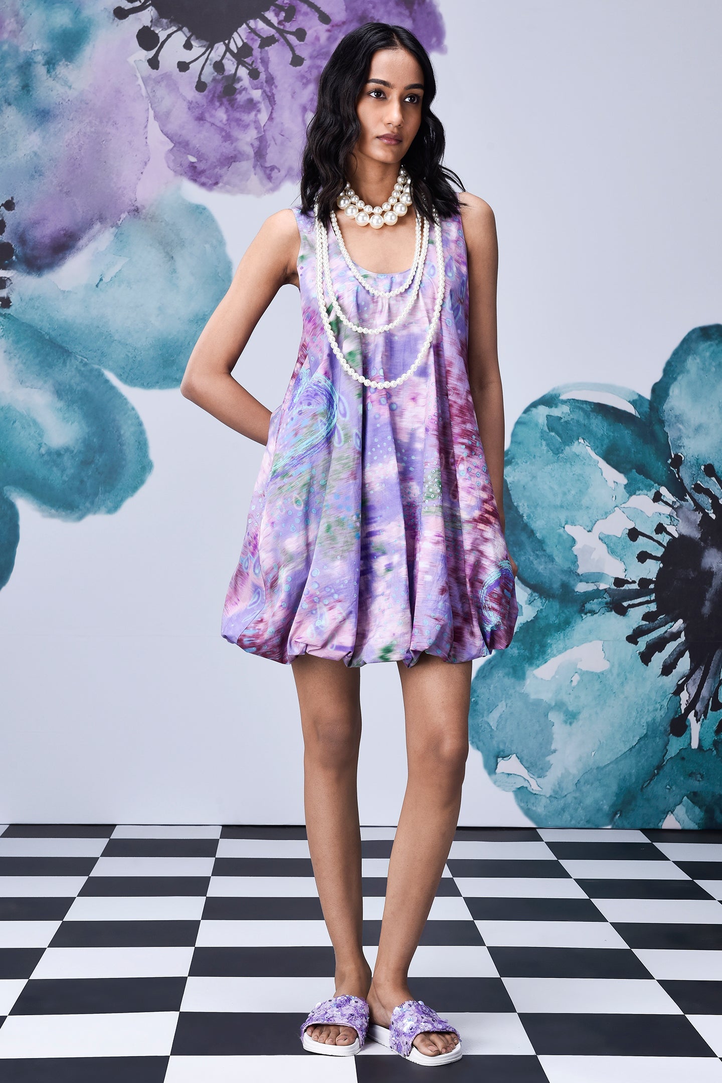 Stylera model wearing French lavender balloon dress with watercolor floral print and pearl necklace