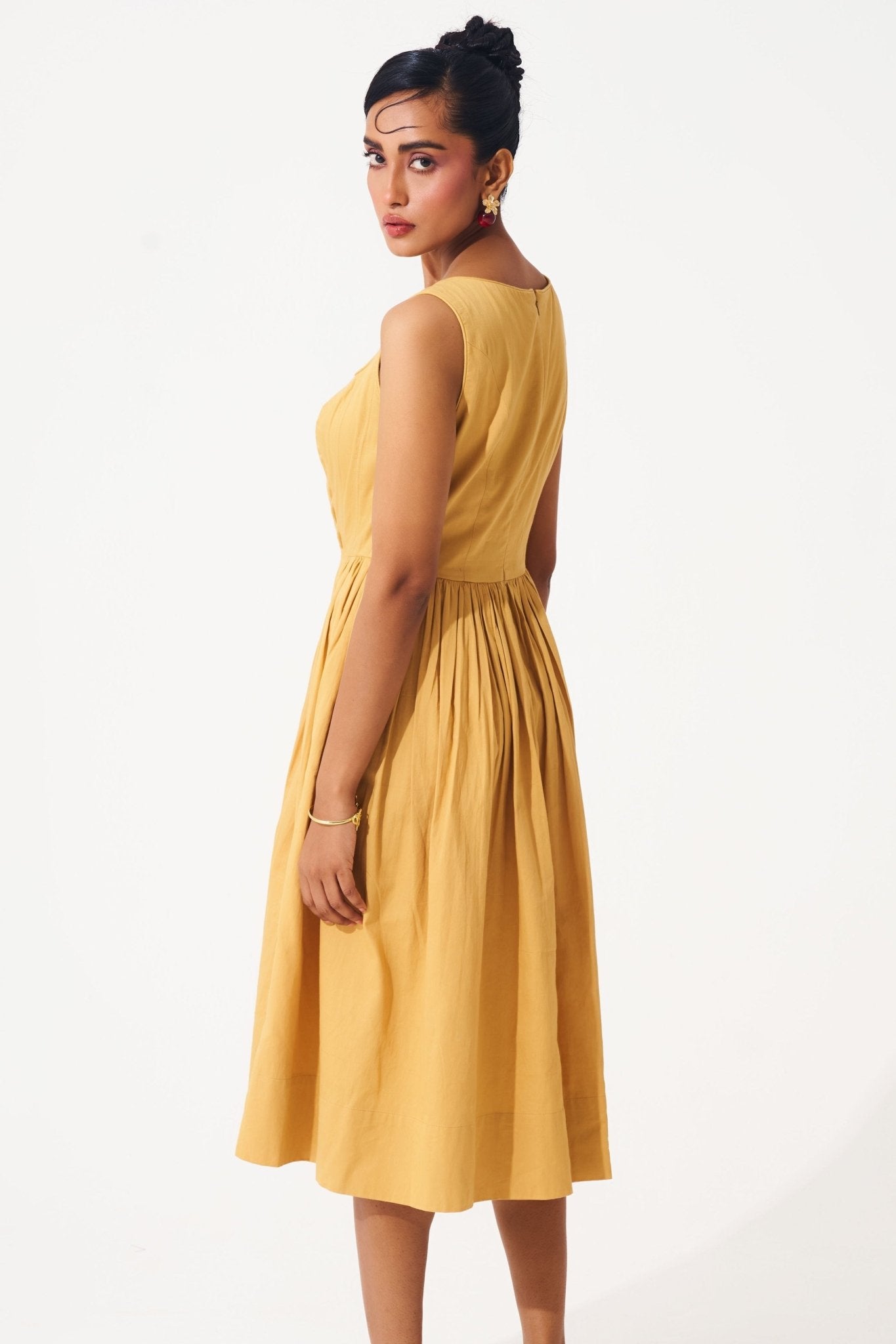 Stylera gold cotton corset dress sleeveless midi fit with pleated skirt worn by model