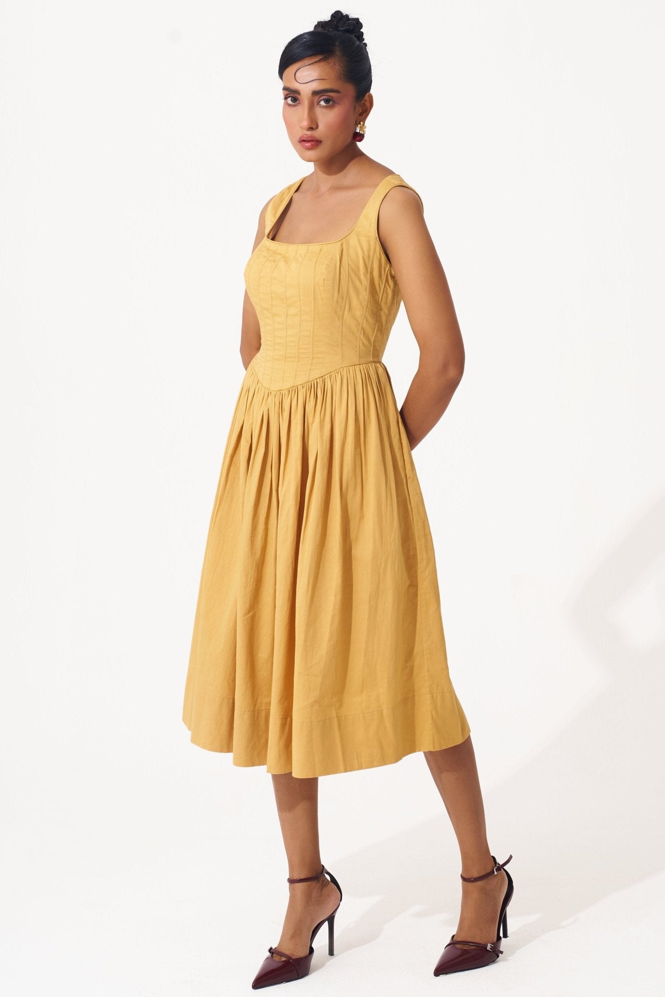 Stylera gold cotton corset dress with square neckline and midi skirt worn by model