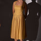 Stylera gold cotton corset dress with sleeveless design and midi length worn by model