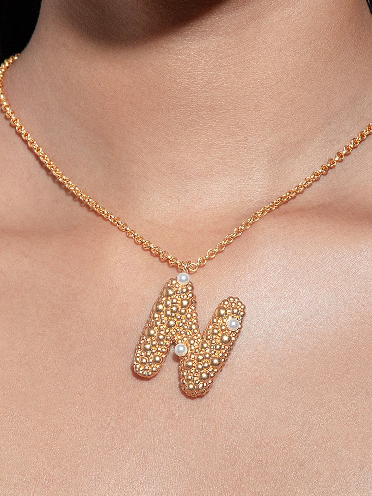 stylera gold letter N pendant necklace with textured beaded N and pearl accents on chain