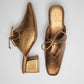 Stylera trendy slip-on shoes for women in metallic gold heels with bow detail
