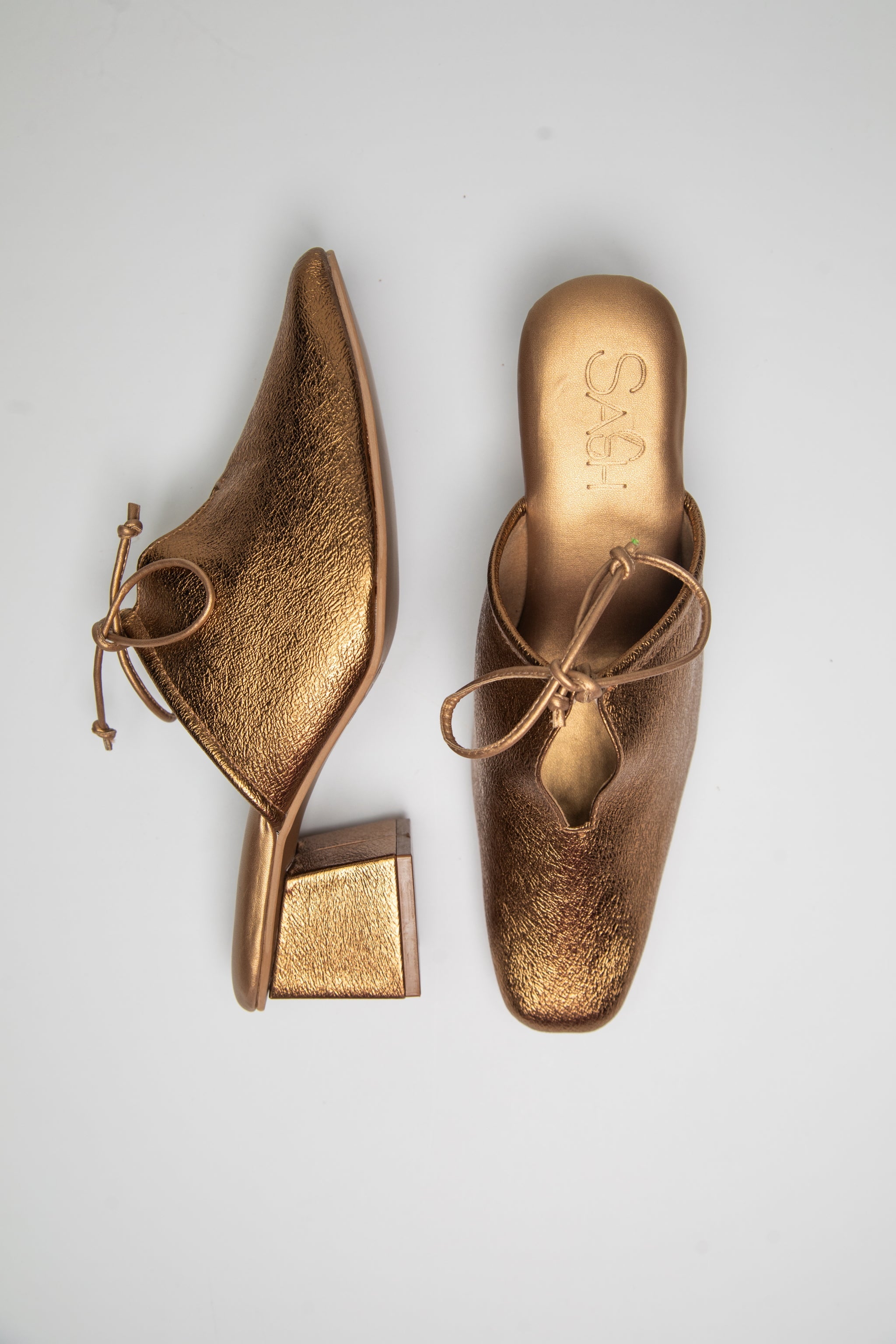 Stylera trendy slip-on shoes for women in metallic gold heels with bow detail