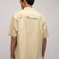 Stylera beige short sleeve graphic polo shirt for men back view with printed NO THING CHANGES text and relaxed fit