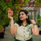 Stylera green embroidered linen top with floral design worn by woman in outdoor garden setting