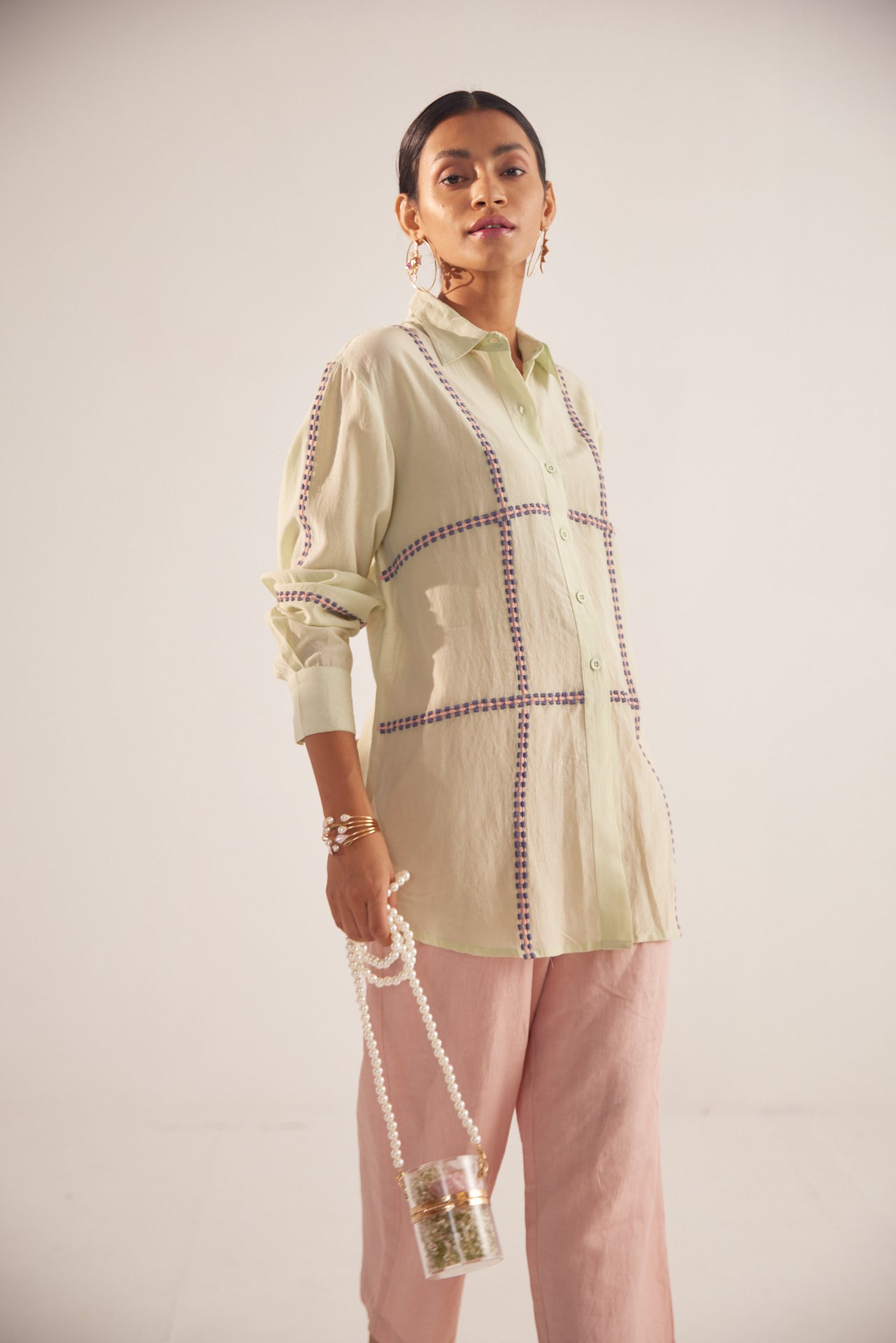 Stylera green embroidered oversized shirt worn by model with pink pants and pearl handbag