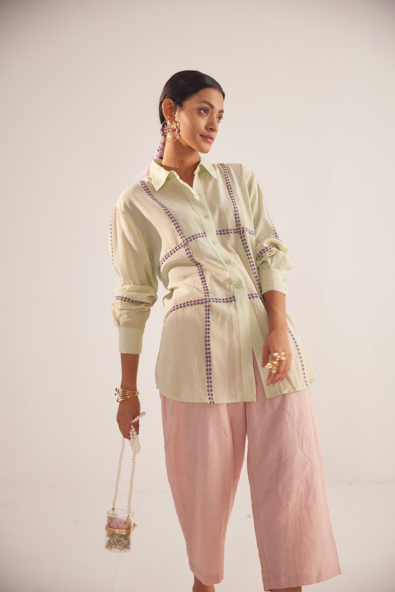 Stylera green embroidered oversized shirt worn by model with pink wide-leg pants and accessories