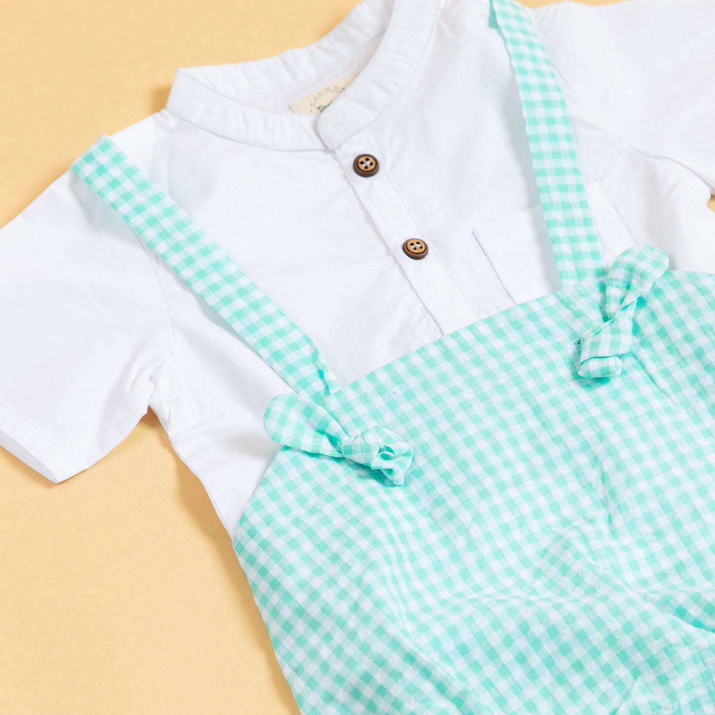 Cute green gingham baby romper with button details and adjustable straps for stylish infants
