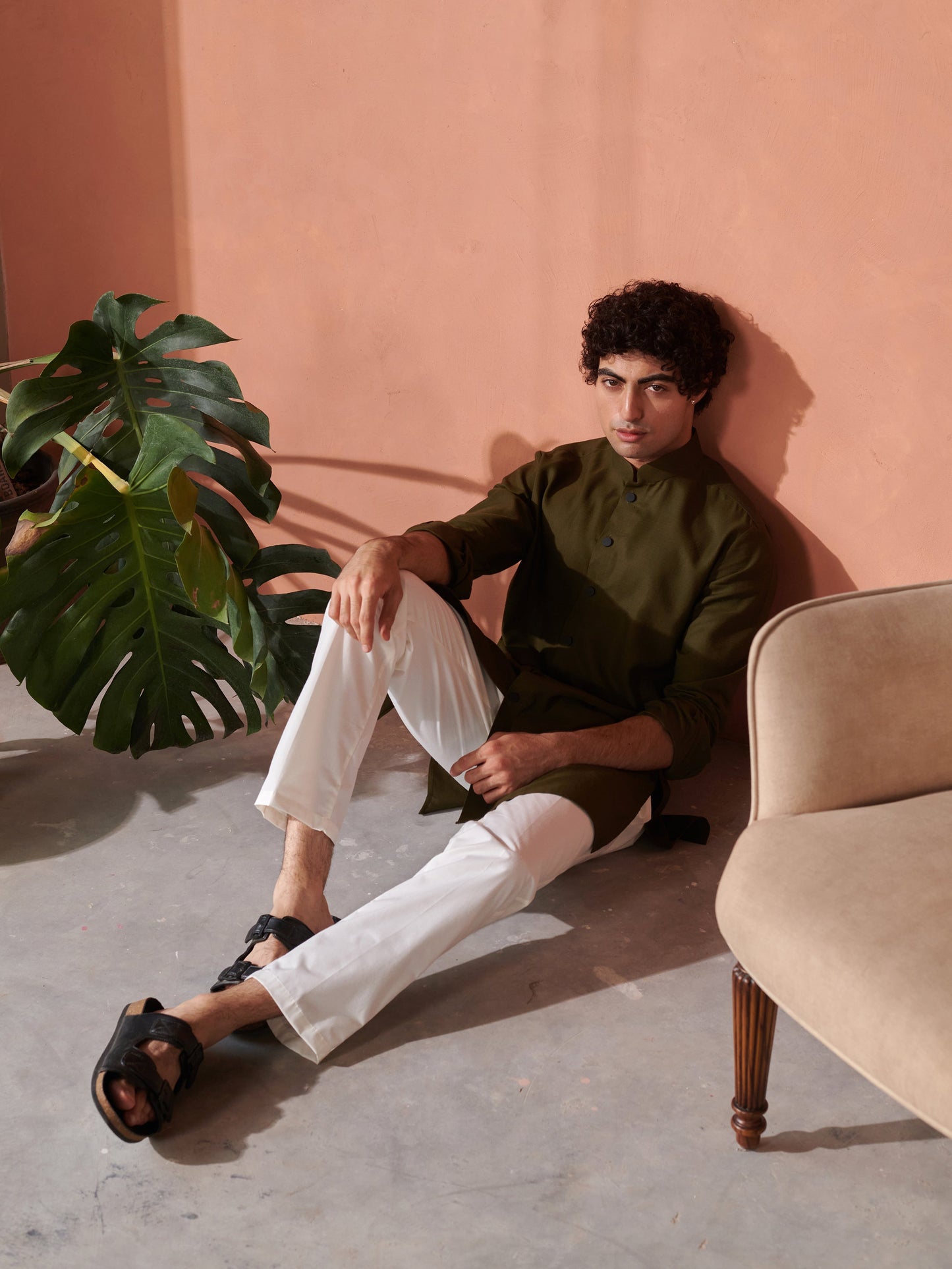 Stylish green Jodhpuri kurta paired with white trousers, set in a modern indoor space