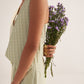 Stylera green lace straight fit trousers worn by model holding purple flowers