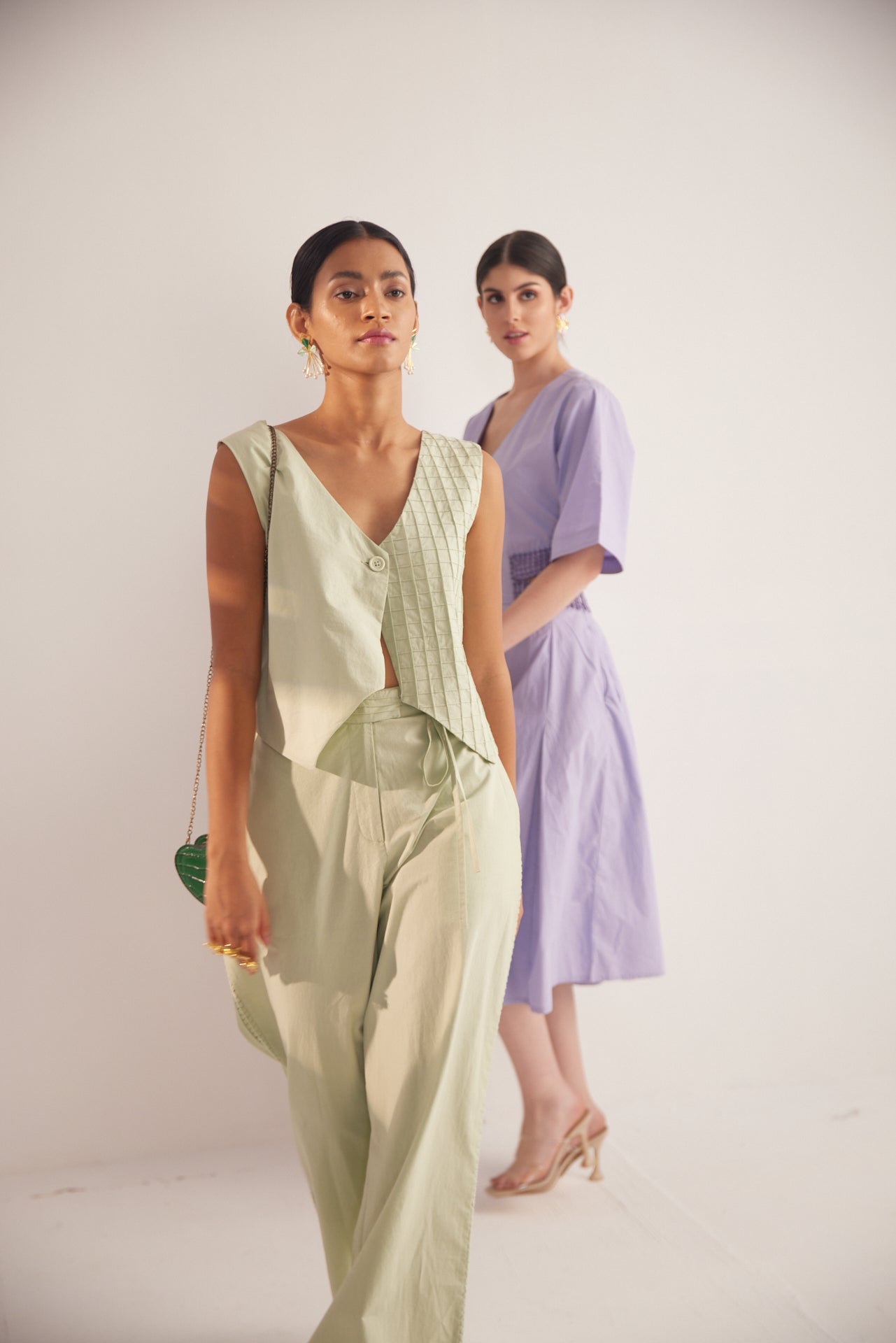 Stylera green lace straight fit trousers worn by model with sleeveless top in soft lighting