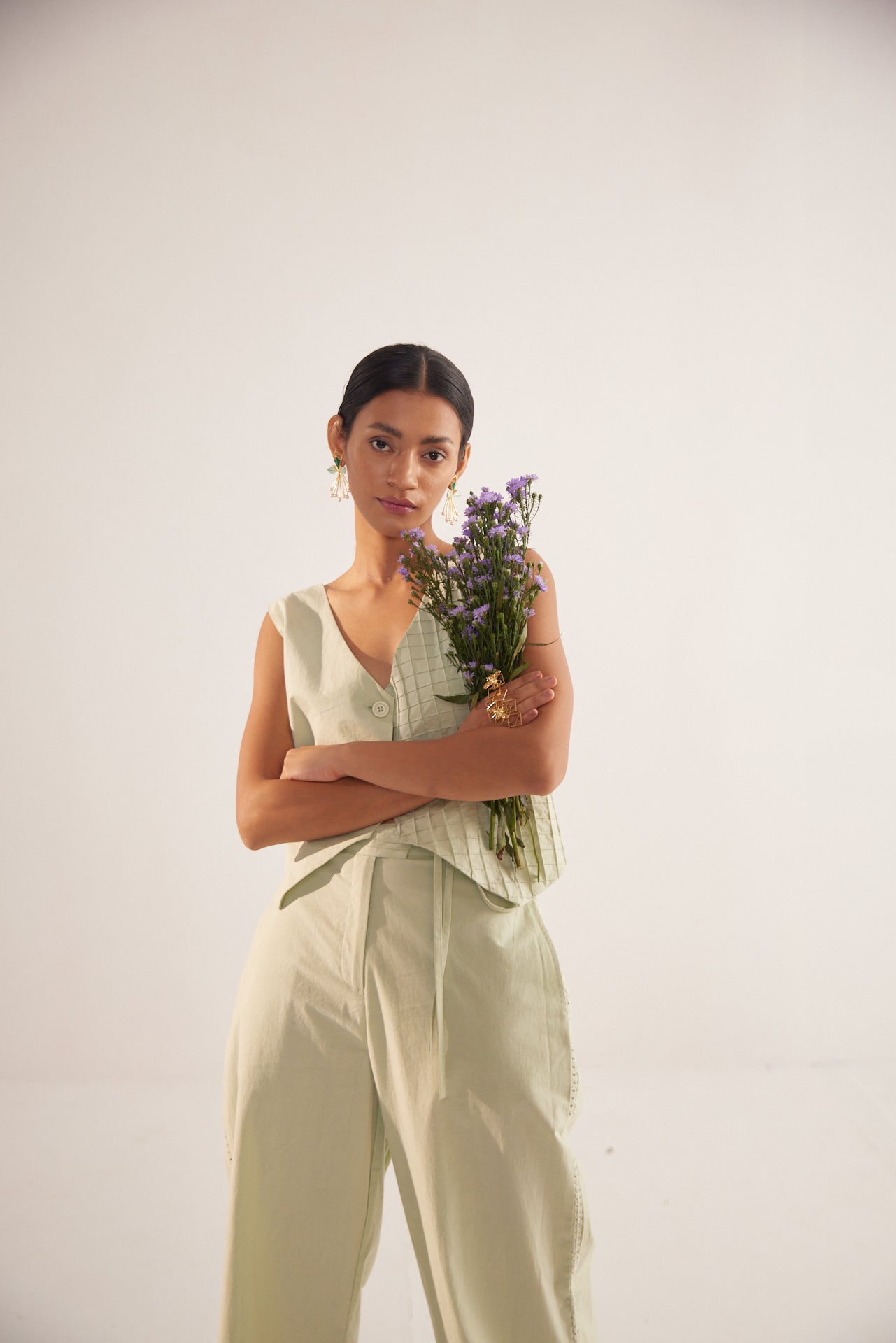 Stylera green lace straight fit trousers worn by woman holding a bouquet of flowers