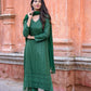 Woman wearing green three piece suit for women with scarf and detailed embroidery outdoors