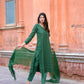 Woman wearing green three piece suit for women standing outdoors with matching dupatta and pants