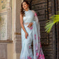 Elegant woman wearing a handcrafted saree with floral print, featuring a light blue color and vibrant flowers