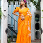 Elegant model in an orange handpainted chiffon saree with floral designs, posing outdoors