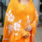 Beautiful handpainted chiffon saree in vibrant orange with floral designs, perfect for festive occasions
