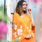 Elegant woman posing in a bright orange handpainted chiffon saree adorned with floral designs
